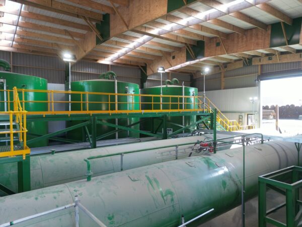 Inside of Permapine Treatment Plant with rafters and boilers looking to the outside